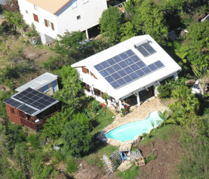 Photo d'une maison vue du dessus avec des modules photovoltaïques sur la toiture et une piscine